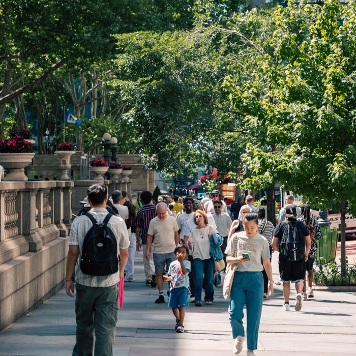 A vibrant summer day at Bryant Park, NYC, with diverse pedestrians enjoying the urban greenery.